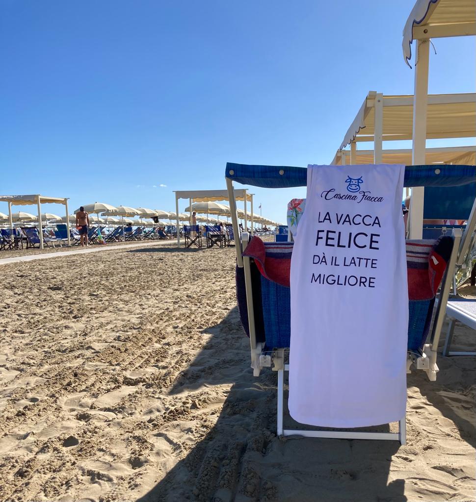 Canottiera Cascina Fiacca appoggiata su un lettino in spiaggia